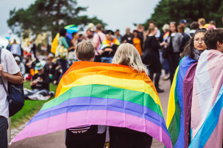 Helsinki, Finland - June 30, 2018: Two girls with rainbow flag in Kaivopuisto garden on Helsinki pride festival